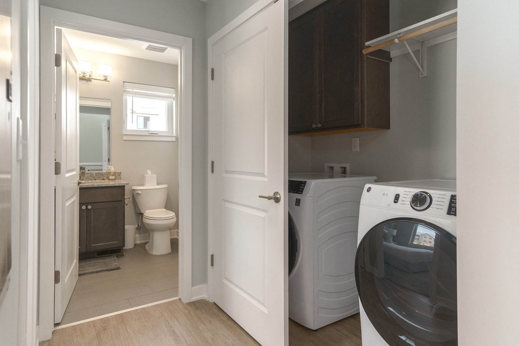 a laundry room with a washer and dryer and a bathroom with a toilet