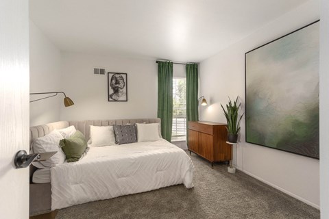 a bedroom with a bed and a painting on the wall