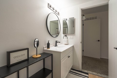 a white bathroom with a sink and a mirror