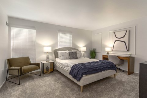 a bedroom with a bed and a desk and a chair