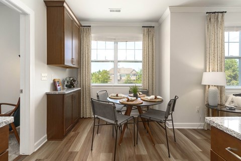 a dining room with a table and chairs in front of a window