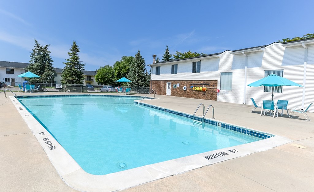 A swimming pool with blue water and white lane markers.