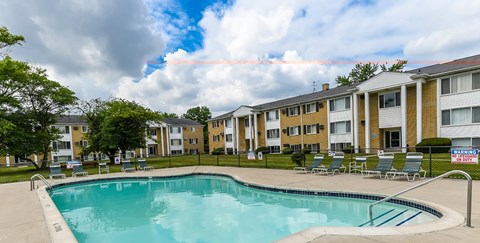 A swimming pool in front of apartment buildings.