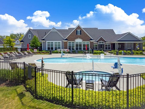 A large house with a pool in front.
