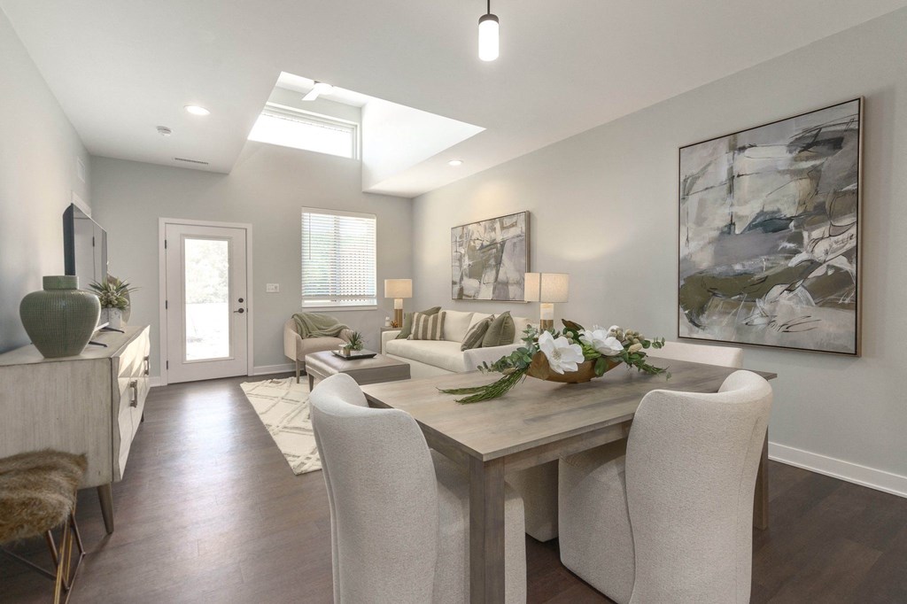 a living room and dining room with white chairs and a table