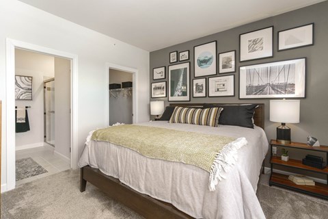 a bedroom with a bed and pictures on the wall