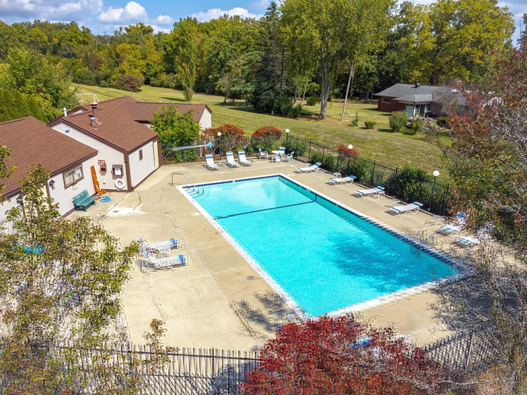A swimming pool surrounded by trees and a house.