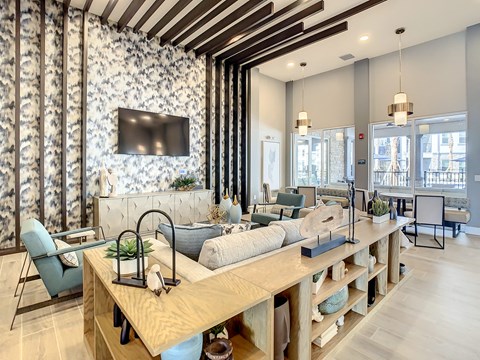 A modern living room with a wooden table and a TV mounted on the wall.