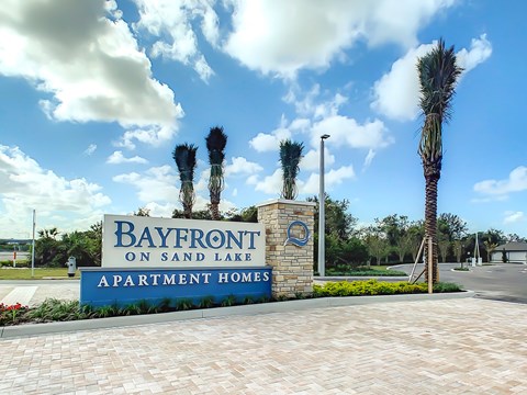 Bayfront on Sand Lake Apartment Homes sign with palm trees.