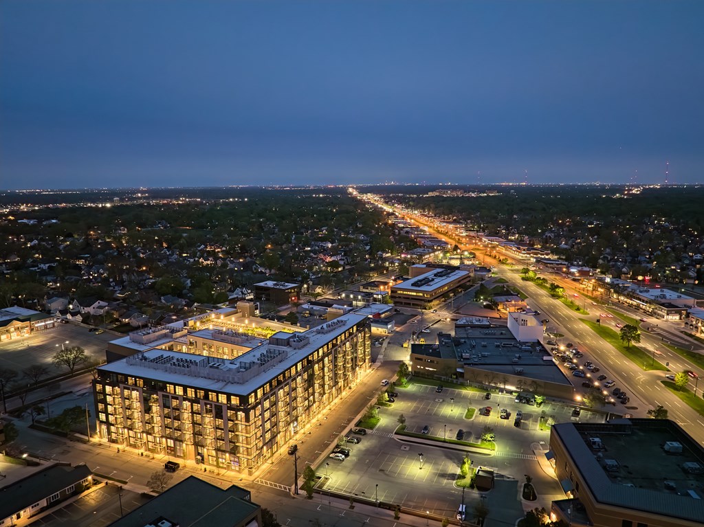 A cityscape at night with a large building in the foreground.