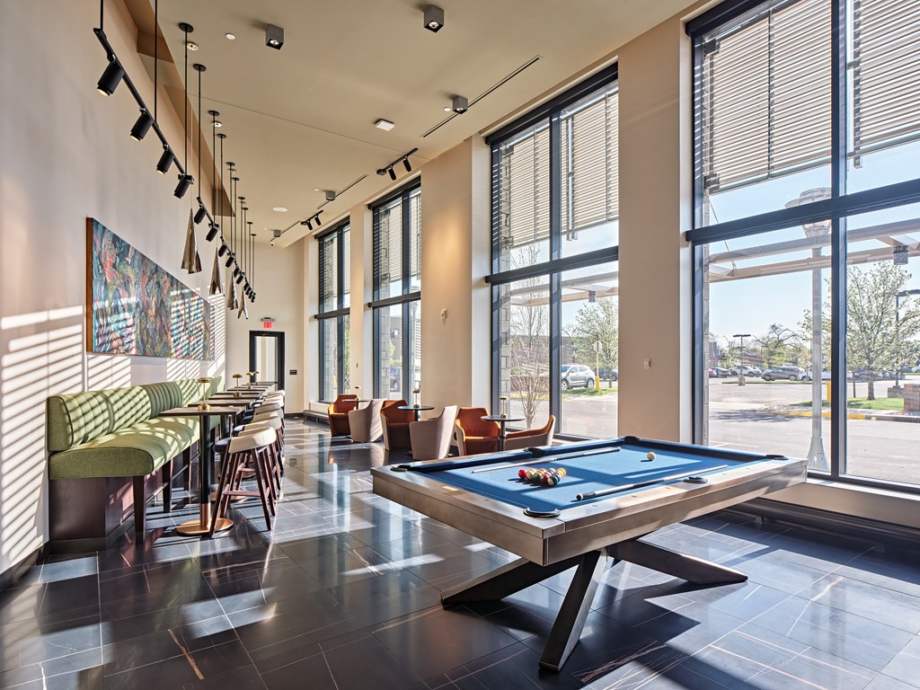 A billiard table is in the middle of a room with a pool table and a bar.