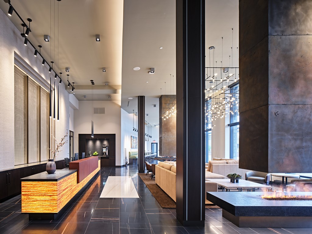 A modern lobby with a reception desk and a large window.