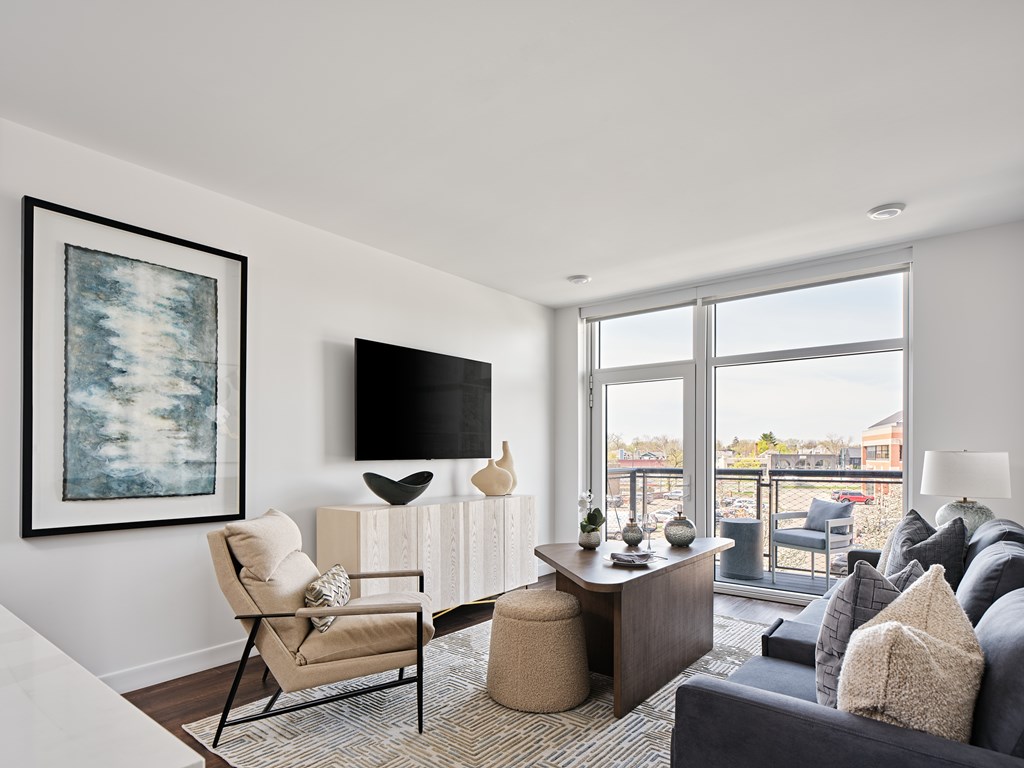 A living room with a chair, a table, and a painting on the wall.