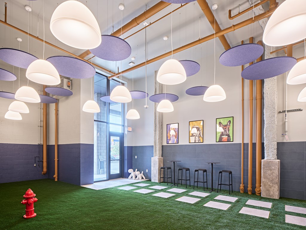 A room with a green floor and a red fire hydrant.