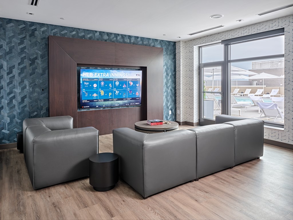 A modern living room with a television displaying "FIVE EXTRA INNINGS" and comfortable seating.
