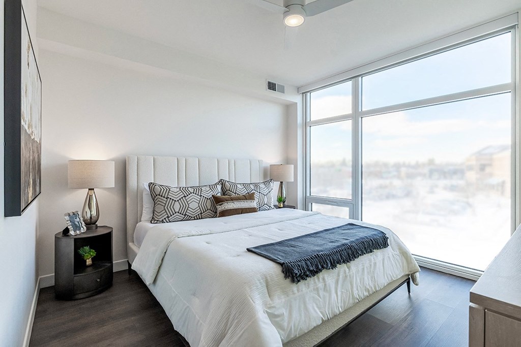 A bedroom with a large bed and a view of the city.