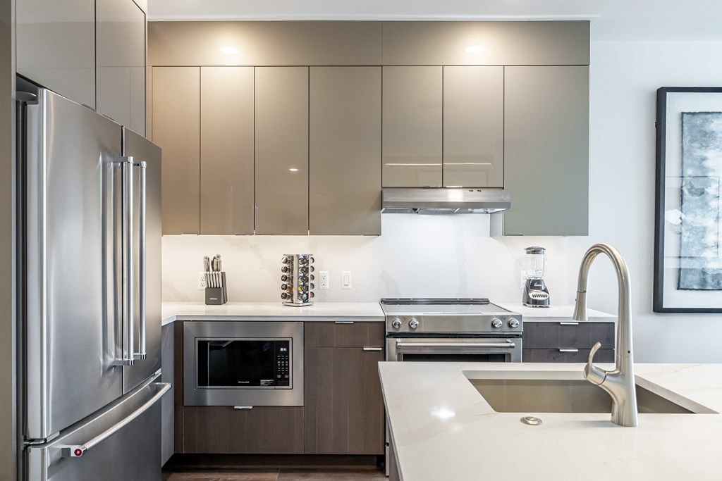 A modern kitchen with stainless steel appliances and a white countertop.