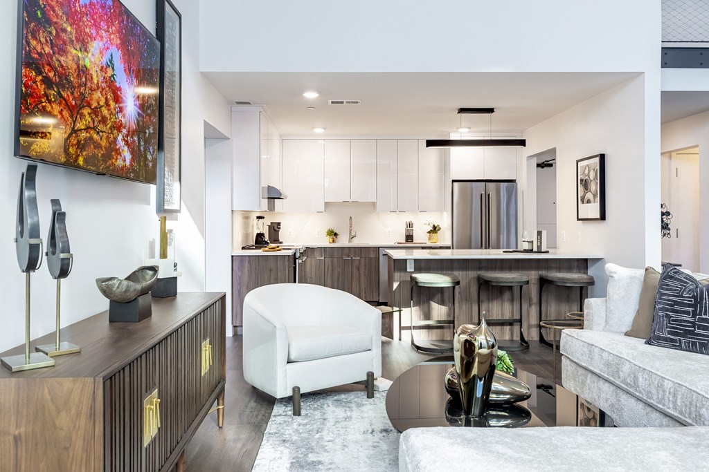 A modern living room with a white sofa and a wooden cabinet.