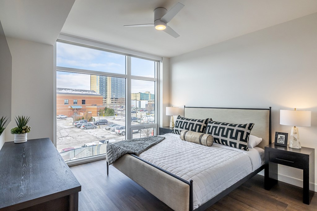 A bedroom with a large bed and a view of the city.