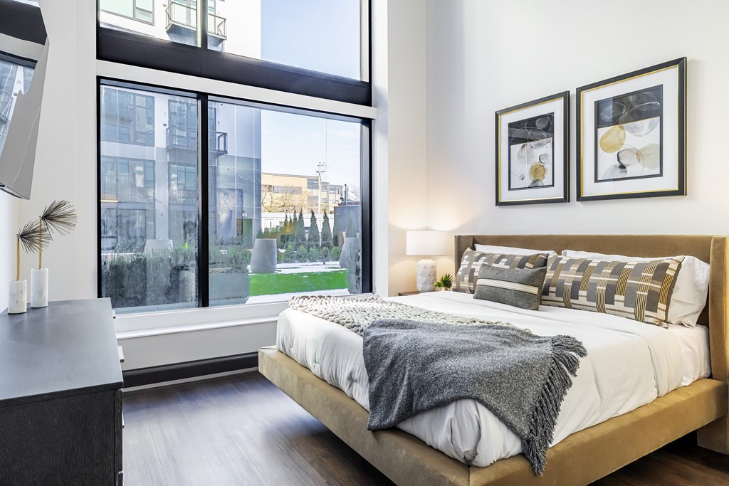 A bedroom with a large bed and a view of the city.