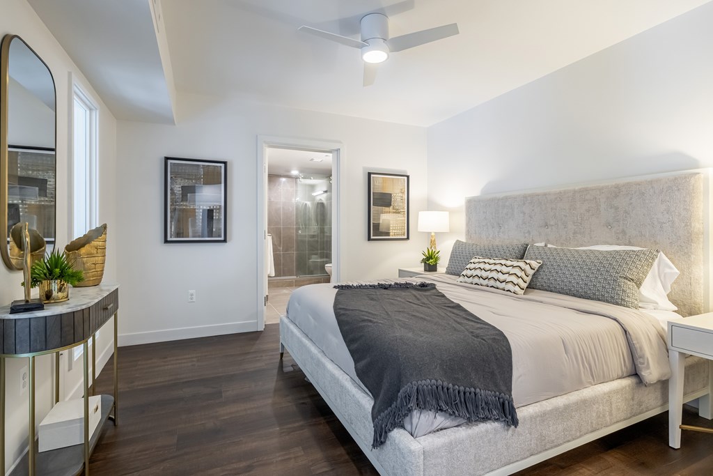 A bedroom with a large bed and a mirror on the wall.