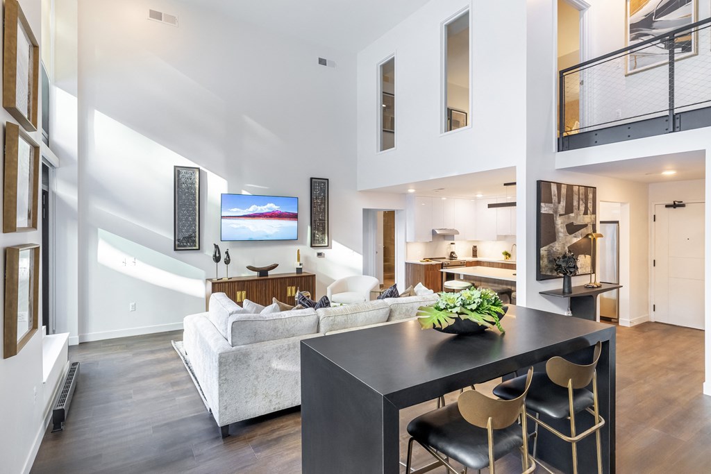 A modern living room with a white couch and a black table.