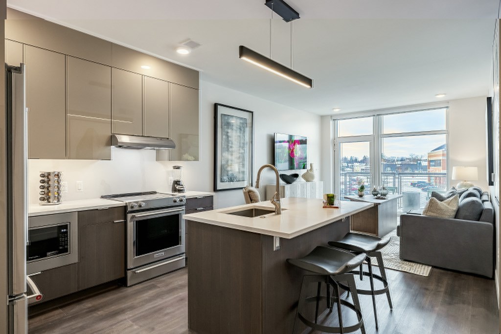 A modern kitchen with a large island and stainless steel appliances.