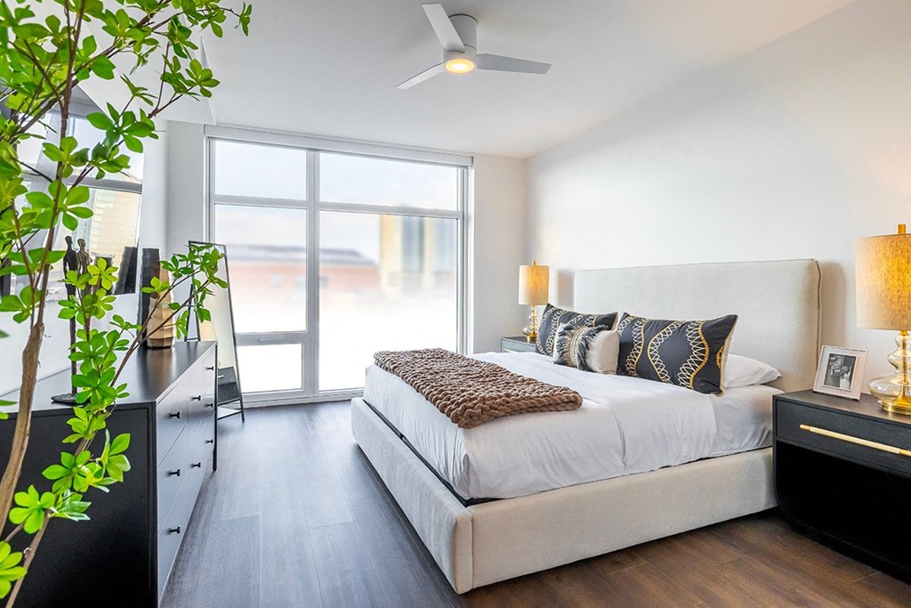 A bedroom with a large bed and a ceiling fan.