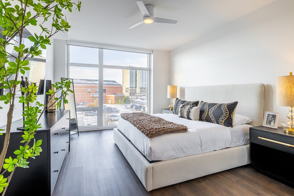 A bedroom with a large bed and a ceiling fan.