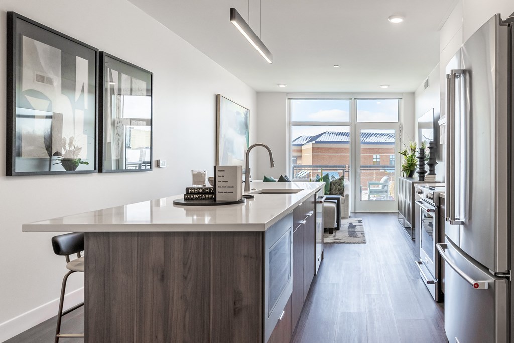 A modern kitchen with a wooden island and stainless steel appliances.