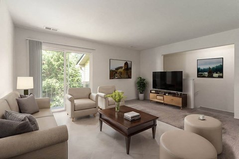 A modern living room with a grey couch, a wooden coffee table, a flat screen TV, and a large window with a view of trees.