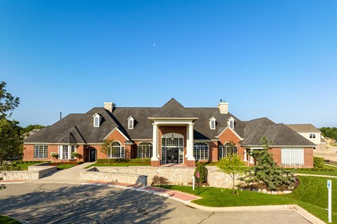 a large house with a street in front of it and a blue sky
