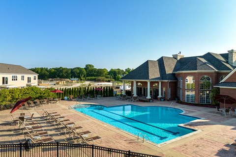 an aerial view of a swimming pool with a house and a resort style pool