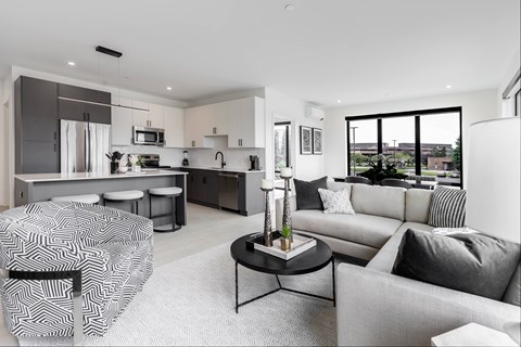 A modern living room with a grey sofa and a black and white patterned chair.
