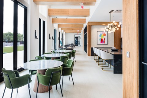 A modern dining room with green chairs and a long table.