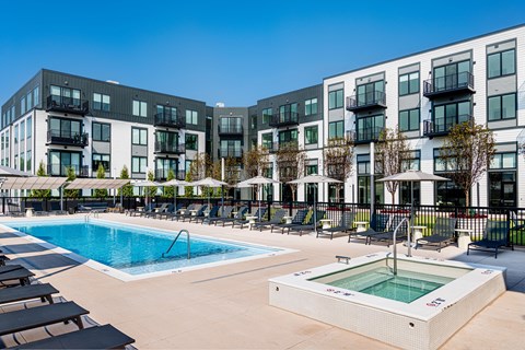 A swimming pool area in front of apartment buildings.