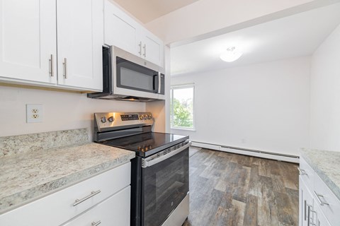 A kitchen with a black microwave above a stove top oven.
