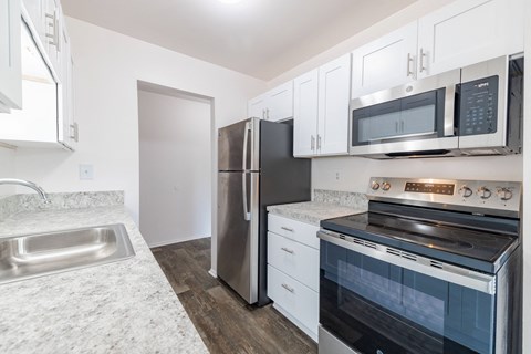 A kitchen with a stainless steel refrigerator, oven, and microwave.