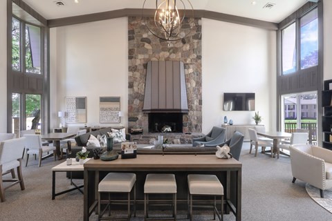 A modern dining room with a stone fireplace and a chandelier.