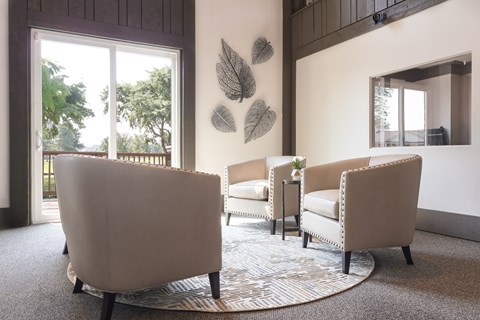 A living room with a large chair and a smaller chair with a table in between.