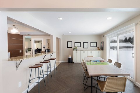 A kitchen with a table and chairs in front of a window.
