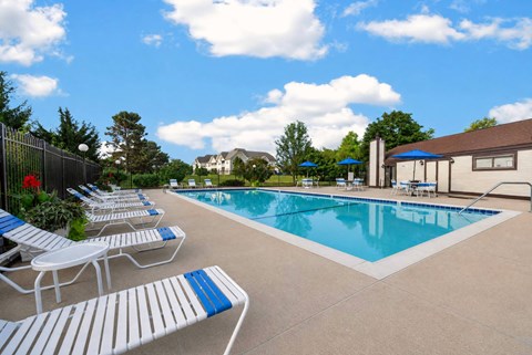 A pool with blue and white lounge chairs.