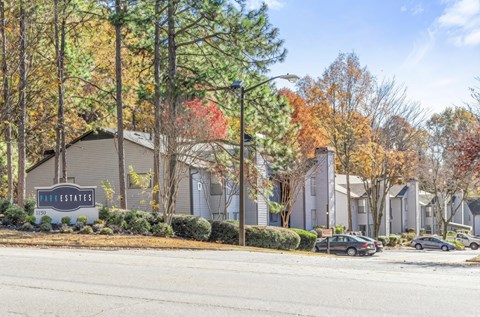 A sign that says "Pine Estates" is in front of some houses.