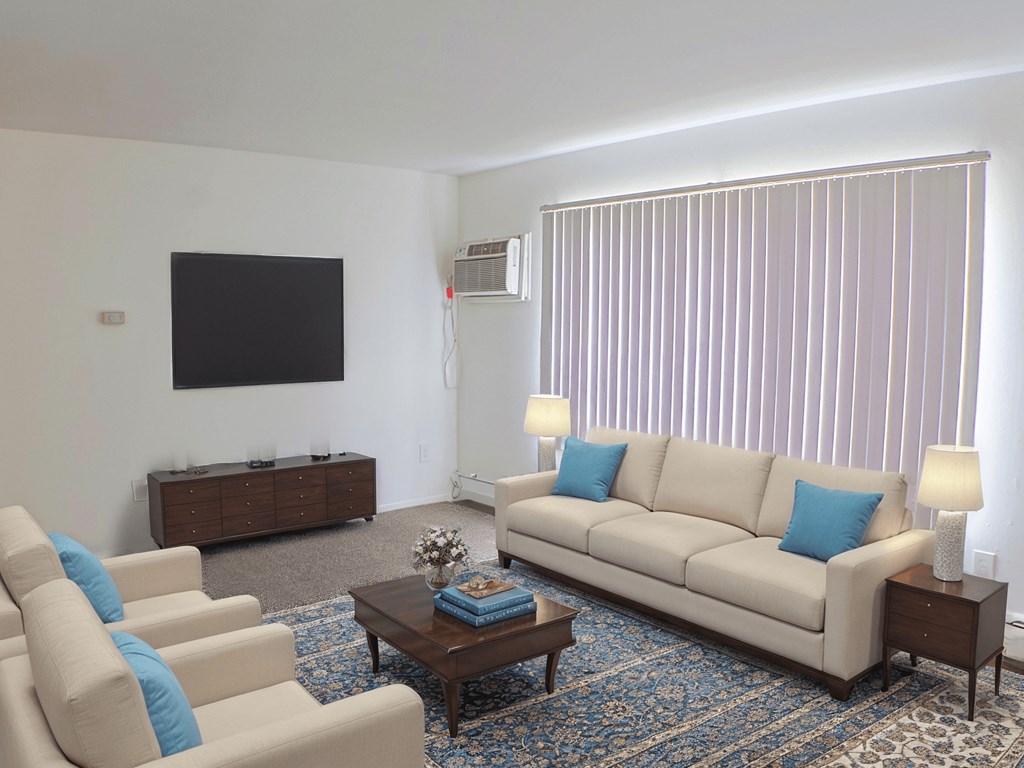 A living room with a couch, chairs, and a coffee table.