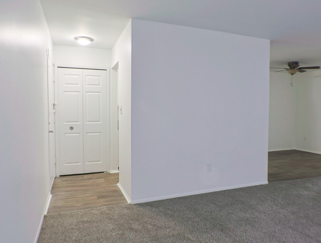 A white door is in a room with a ceiling fan.