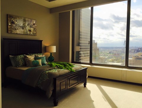 A bedroom with a large bed and a view of the city.