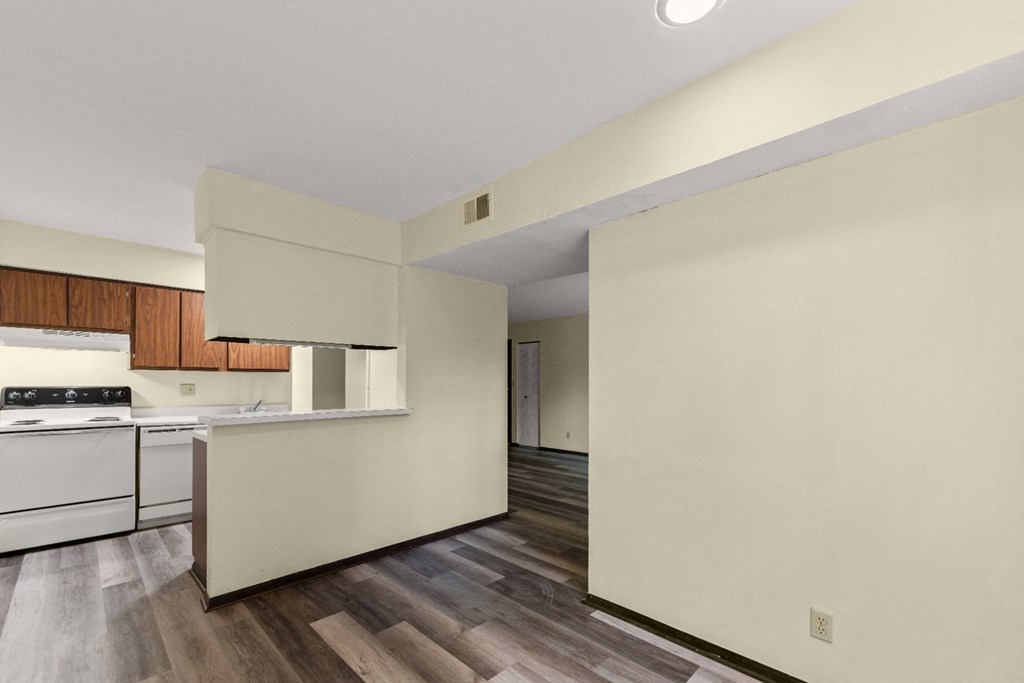 A kitchen with a white stove top oven and a white counter top.