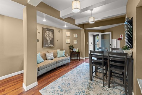 A living room with a grey sofa, two chairs and a rug.