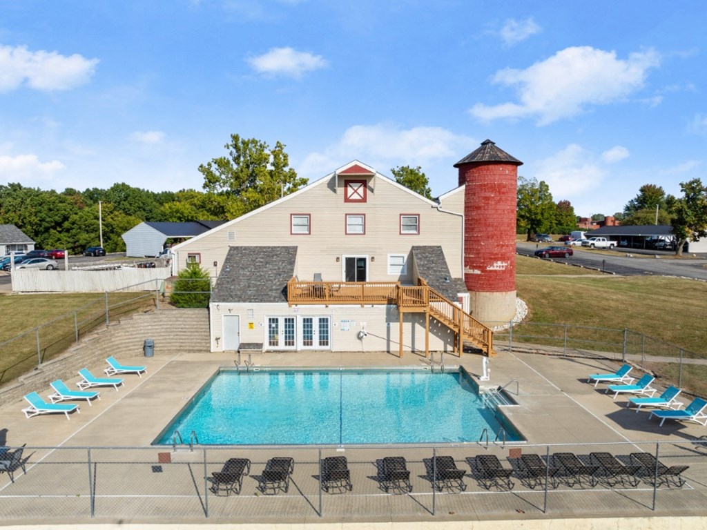 A pool area with a building and a red tower.