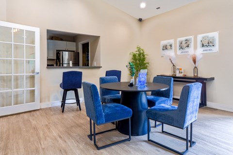 A dining room with blue chairs and a table.